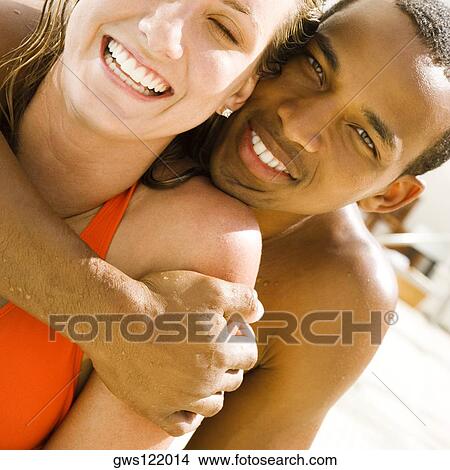 Portrait of a young man embracing a young woman from behind View Large Photo Image Picture - Portrait of a young man embracing a young woman from behind. Fotosearch