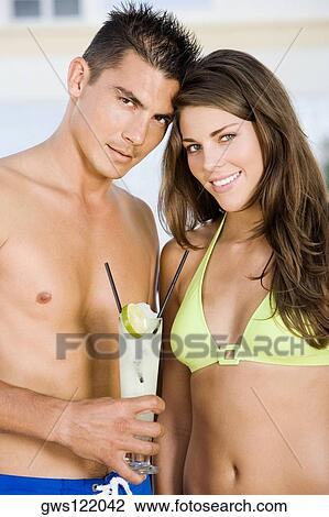 Portrait of a young man holding lemonade with a young woman standing beside him View Large Photo Image Stock Image - Portrait of a young man holding lemonade with a young woman standing beside him. Fotosearch