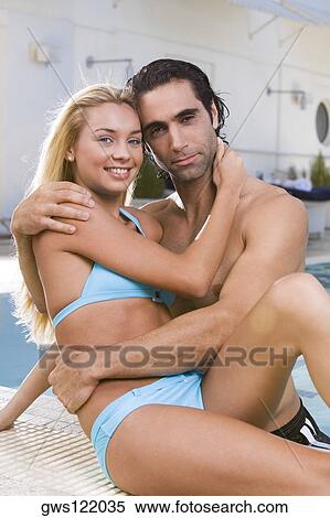 Portrait of a young woman and a mid adult man embracing at the poolside View Large Photo Image Stock Photography - Portrait of a young woman and a mid adult man embracing at the poolside. Fotosearch