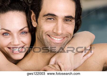 Portrait of a young woman embracing a mid adult man from behind View Large Photo Image Stock Image - Portrait of a young woman embracing a mid adult man from behind. Fotosearch