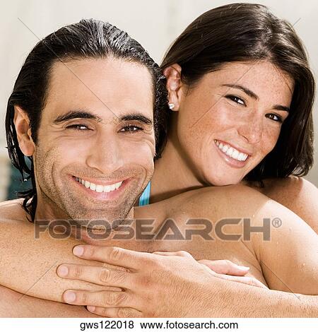 Portrait of a young woman hugging a mid adult man from behind View Large Photo Image Stock Photo - Portrait of a young woman hugging a mid adult man from behind. Fotosearch