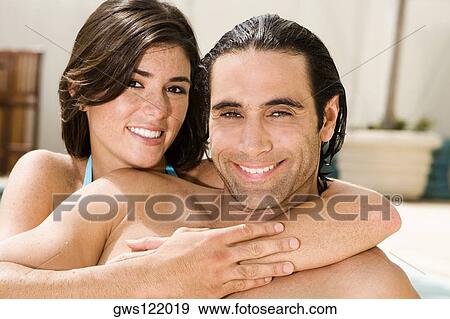 Portrait of a young woman hugging a mid adult man from behind View Large Photo Image Stock Photo - Portrait of a young woman hugging a mid adult man from behind. Fotosearch