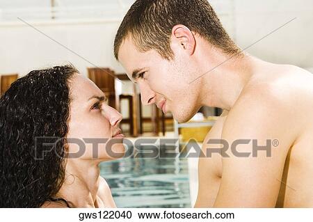 Side profile of a young couple in a swimming pool View Large Photo Image Stock Image - Side profile of a young couple in a swimming pool. Fotosearch