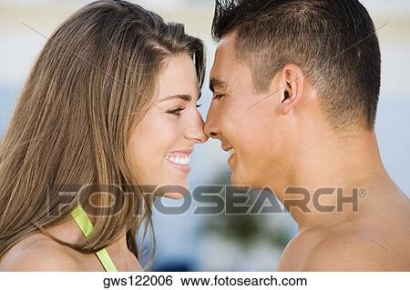 Side profile of a young couple rubbing their noses View Large Photo Image Stock Photograph - Side profile of a young couple rubbing their noses. Fotosearch
