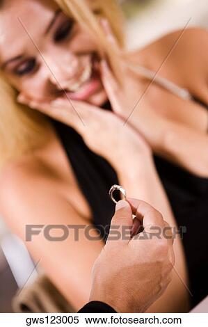 Stock Photography - Close-up of a man giving an engagement ring to a young woman. Fotosearch
