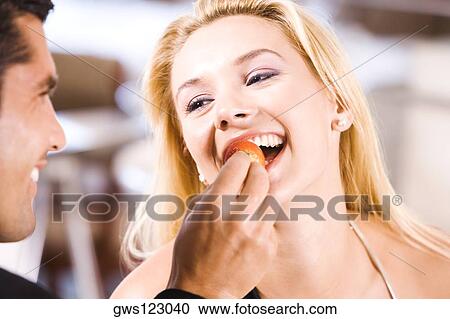 Close-up of a mid adult man feeding a young woman a strawberry View Large Photo Image Stock Image - Close-up of a mid adult man feeding a young woman a strawberry. Fotosearch