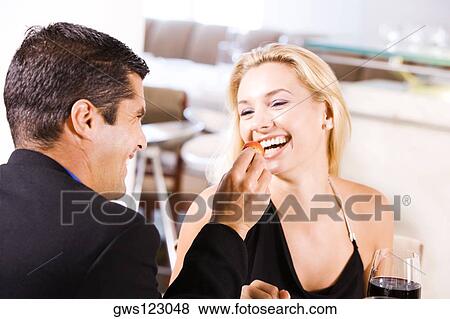 Close-up of a mid adult man feeding a young woman a strawberry View Large Photo Image Stock Photo - Close-up of a mid adult man feeding a young woman a strawberry. Fotosearch