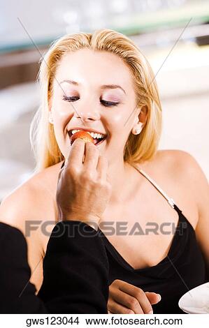 Close-up of a person feeding a young woman a strawberry View Large Photo Image Picture - Close-up of a person feeding a young woman a strawberry. Fotosearch