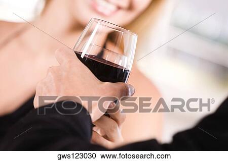 Close-up of a young couple holding glasses of wine View Large Photo Image Stock Image - Close-up of a young couple holding glasses of wine. Fotosearch