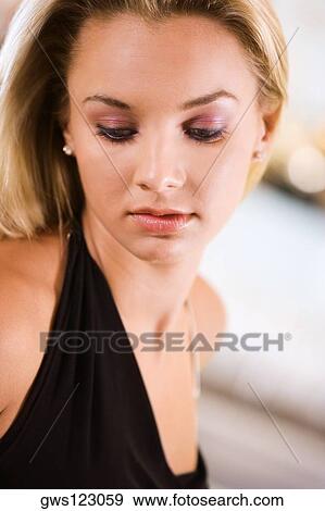 Close-up of a young woman looking down View Large Photo Image Stock Photo - Close-up of a young woman looking down. Fotosearch