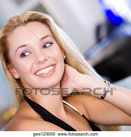 Stock Image - Close-up of a young woman with her hand in her hair. Fotosearch