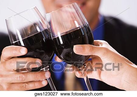 Stock Photo - Close-up of two people toasting with wineglasses. Fotosearch