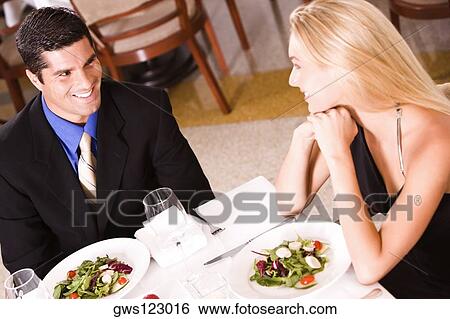 Stock Photograph - High angle view of a mid adult man and a young woman sitting at a table in a restaurant. Fotosearch