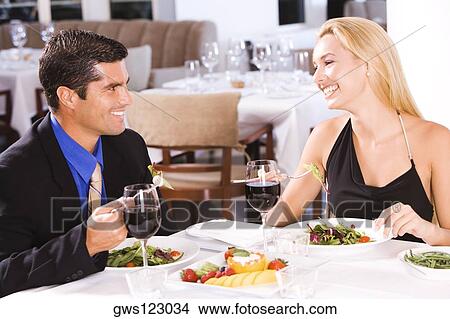 Mid adult man and a young woman sitting in a restaurant View Large Photo Image Picture - Mid adult man and a young woman sitting in a restaurant. Fotosearch