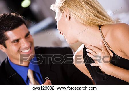 Stock Image - Mid adult man giving an engagement ring to a young woman. Fotosearch