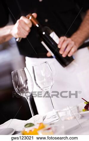 Mid section view of a man opening the cork of a wine bottle View Large Photo Image Stock Image - Mid section view of a man opening the cork of a wine bottle. Fotosearch