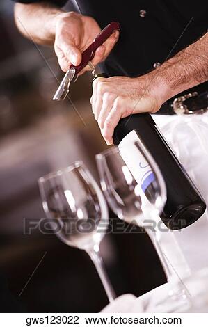 Mid section view of a man opening the cork of a wine bottle View Large Photo Image Stock Image - Mid section view of a man opening the cork of a wine bottle. Fotosearch