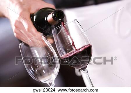 Mid section view of a man pouring red wine into a wineglass View Large Photo Image Picture - Mid section view of a man pouring red wine into a wineglass. Fotosearch