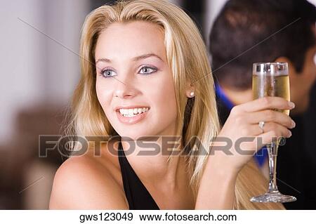 Young woman holding a champagne flute View Large Photo Image Stock Photo - Young woman holding a champagne flute. Fotosearch