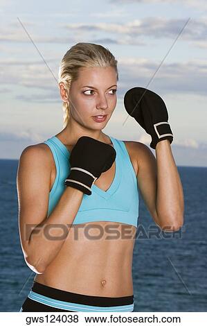 Close-up of a young woman wearing boxing gloves View Large Photo Image Stock Photo - Close-up of a young woman wearing boxing gloves. Fotosearch