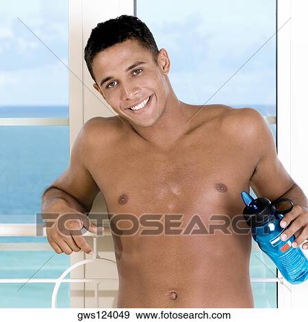 Portrait of a young man holding a bottle of water View Large Photo Image Stock Photo - Portrait of a young man holding a bottle of water. Fotosearch
