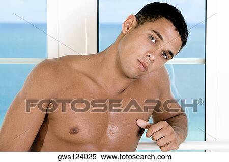 Portrait of a young man leaning against a window View Large Photo Image Stock Photography - Portrait of a young man leaning against a window. Fotosearch