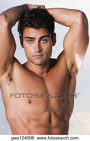 Portrait of a young man with his hands behind his head View Large Photo Image Stock Photograph - Portrait of a young man with his hands behind his head. Fotosearch