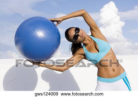 Young woman exercising with a fitness ball View Large Photo Image Stock Photo - Young woman exercising with a fitness ball. Fotosearch