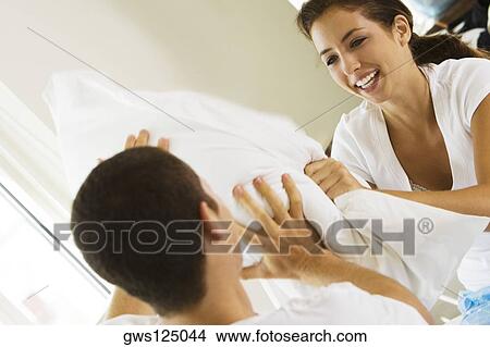 Close-up of a young couple having a pillow fight View Large Photo Image Picture - Close-up of a young couple having a pillow fight. Fotosearch