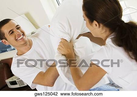 Close-up of a young couple having a pillow fight View Large Photo Image Stock Image - Close-up of a young couple having a pillow fight. Fotosearch