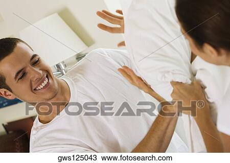 Close-up of a young couple having a pillow fight View Large Photo Image Stock Image - Close-up of a young couple having a pillow fight. Fotosearch