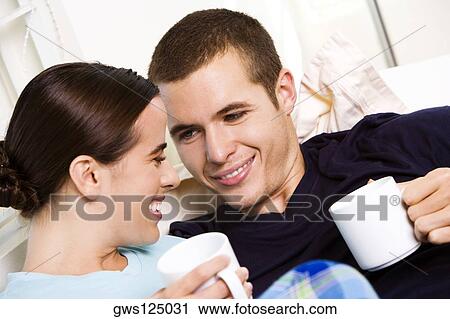Close-up of a young couple holding coffee cups View Large Photo Image Stock Image - Close-up of a young couple holding coffee cups. Fotosearch