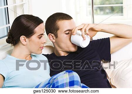 Close-up of a young couple sitting on the bed View Large Photo Image Stock Image - Close-up of a young couple sitting on the bed. Fotosearch