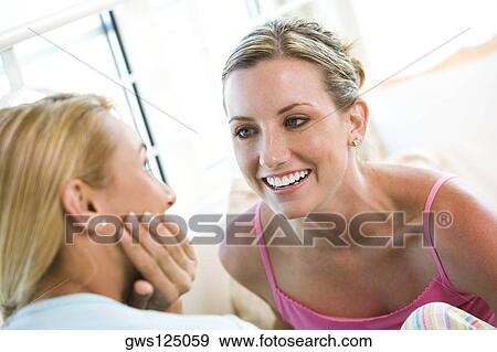Close-up of two young women talking View Large Photo Image Stock Photo - Close-up of two young women talking. Fotosearch