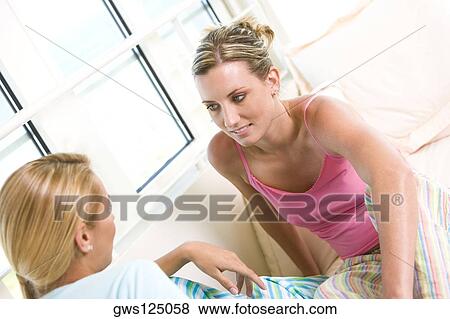 High angle view of two young women talking to each other View Large Photo Image Stock Photo - High angle view of two young women talking to each other. Fotosearch