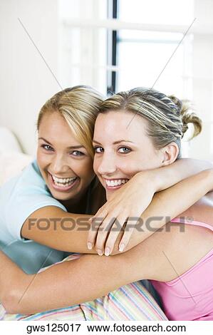 Portrait of two young women hugging each other View Large Photo Image Stock Photo - Portrait of two young women hugging each other. Fotosearch