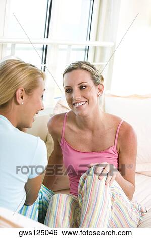 Stock Photograph - Two young women talking to each other. Fotosearch