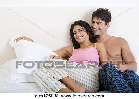 Stock Photo - Young couple lying on the bed. Fotosearch