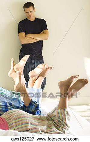 Young man looking at four young women lying on the bed View Large Photo Image Stock Photo - Young man looking at four young women lying on the bed. Fotosearch