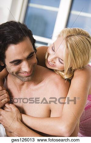 Close-up of a young woman embracing a young man from behind View Large Photo Image Stock Image - Close-up of a young woman embracing a young man from behind. Fotosearch