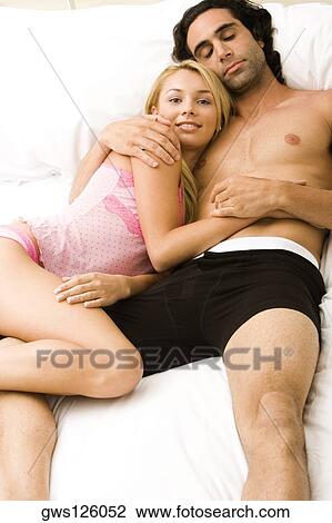 High angle view of a young couple lying on the bed View Large Photo Image Stock Image - High angle view of a young couple lying on the bed. Fotosearch