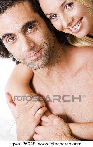 Portrait of a young woman embracing a young man from behind View Large Photo Image Stock Photo - Portrait of a young woman embracing a young man from behind. Fotosearch
