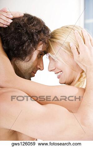 Side profile of a young couple looking at each other View Large Photo Image Stock Photo - Side profile of a young couple looking at each other. Fotosearch