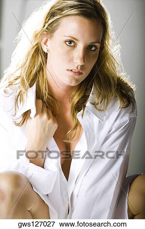 Portrait of a young woman holding her shirt collar View Large Photo Image Stock Photo - Portrait of a young woman holding her shirt collar. Fotosearch