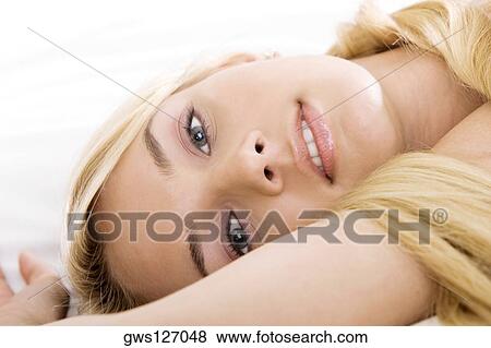 Portrait of a young woman lying on the bed View Large Photo Image Stock Photo - Portrait of a young woman lying on the bed. Fotosearch