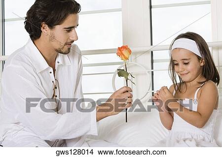 Close-up of a father giving his daughter a rose View Large Photo Image Picture - Close-up of a father giving his daughter a rose. Fotosearch