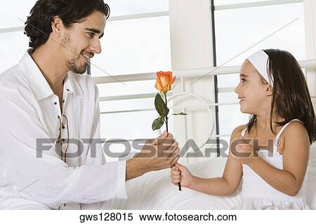 Close-up of a father giving his daughter a rose View Large Photo Image Stock Photography - Close-up of a father giving his daughter a rose. Fotosearch