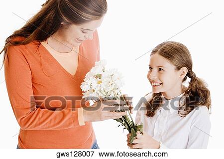 Stock Photo - Close-up of a girl giving her mother a bunch of flowers. Fotosearch