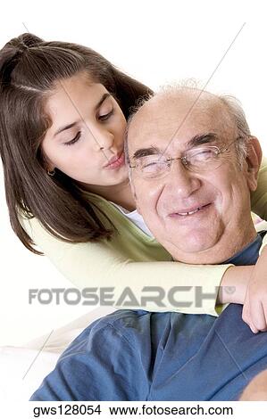Close-up of a granddaughter hugging her grandfather from behind View Large Photo Image Picture - Close-up of a granddaughter hugging her grandfather from behind. Fotosearch