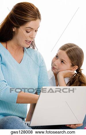 Close-up of a mother and her daughter working on a laptop View Large Photo Image Stock Photo - Close-up of a mother and her daughter working on a laptop. Fotosearch